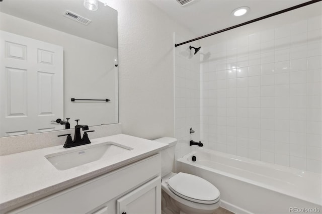 full bathroom featuring vanity, tiled shower / bath combo, and toilet