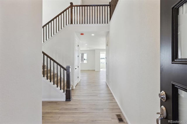 foyer with a high ceiling and light hardwood / wood-style flooring