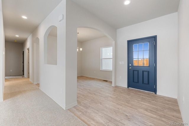 foyer with a notable chandelier and light hardwood / wood-style floors