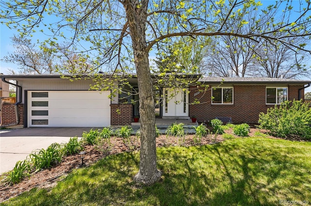 view of front of house featuring brick siding, a garage, driveway, and a front lawn