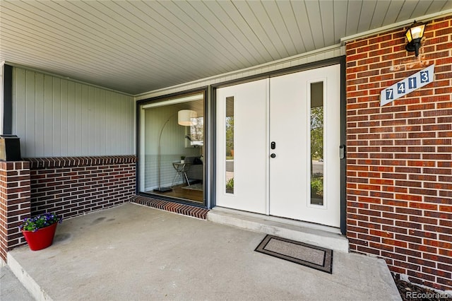 view of exterior entry featuring brick siding