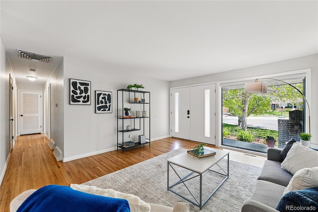 living area with light wood-style flooring and baseboards