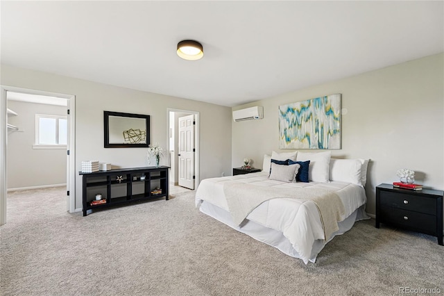 bedroom featuring a wall mounted air conditioner, carpet floors, and baseboards