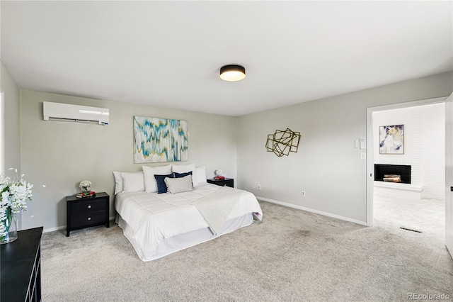 carpeted bedroom with a wall mounted air conditioner, baseboards, and a brick fireplace