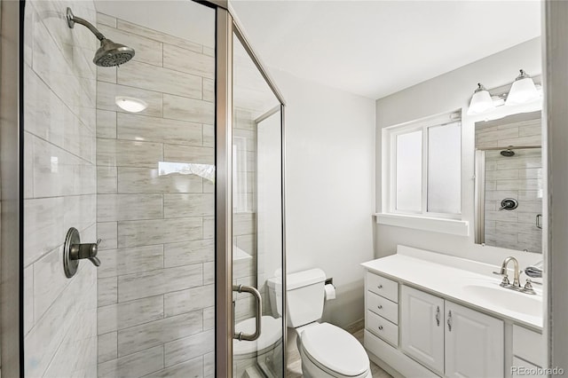 bathroom featuring a stall shower, vanity, and toilet