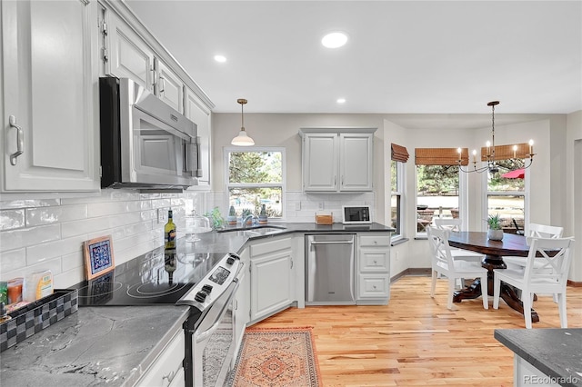 kitchen with recessed lighting, stainless steel appliances, hanging light fixtures, and light wood finished floors