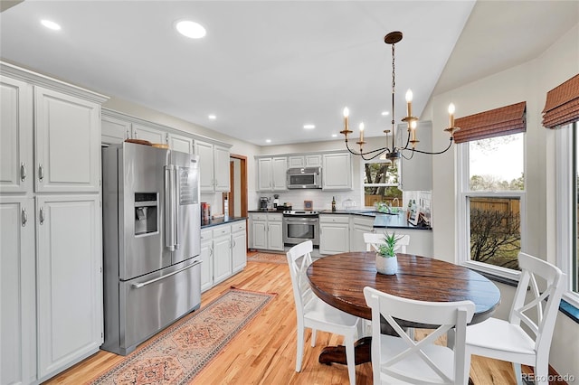 dining space with light wood finished floors and recessed lighting