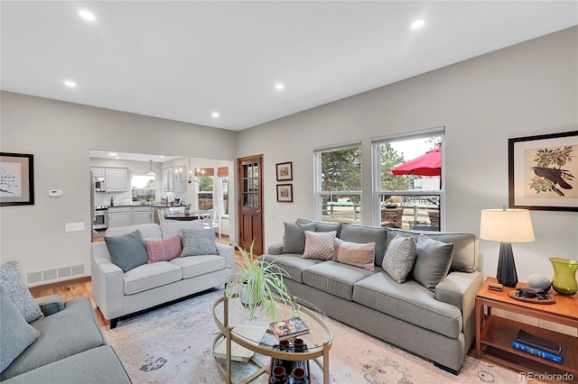 living room featuring recessed lighting, visible vents, and light wood-style flooring