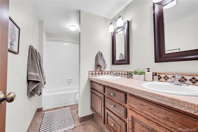 bathroom featuring a sink, toilet, double vanity, and tile patterned flooring