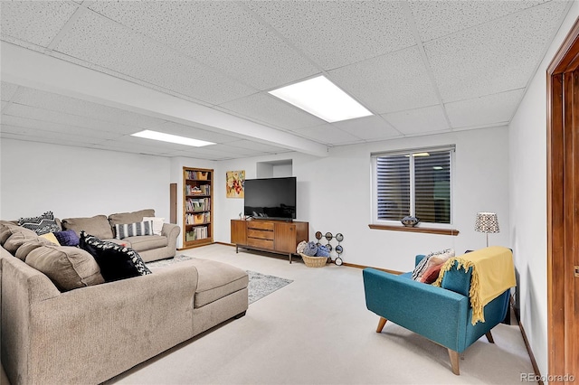 living area with carpet flooring, a paneled ceiling, and baseboards