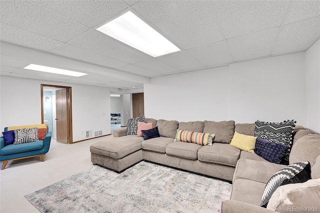 living area with visible vents, a paneled ceiling, and carpet