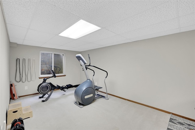 exercise area with a drop ceiling, baseboards, and carpet