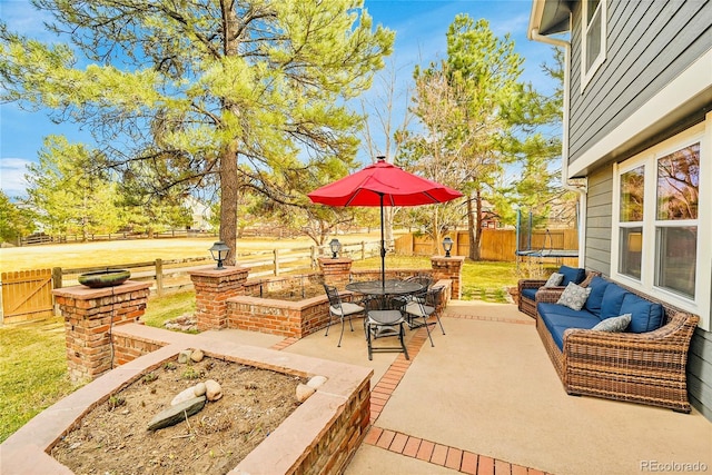 view of patio / terrace with an outdoor hangout area, a trampoline, and a fenced backyard