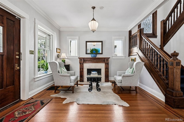 sitting room with stairway, a high end fireplace, ornamental molding, wood finished floors, and baseboards