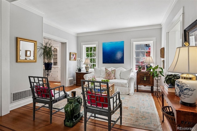 living area with wood finished floors, crown molding, and baseboards