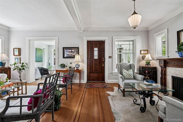 entrance foyer featuring wood finished floors, a premium fireplace, baseboards, ornamental molding, and beam ceiling