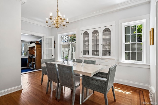 dining room with a chandelier, baseboards, ornamental molding, and wood finished floors