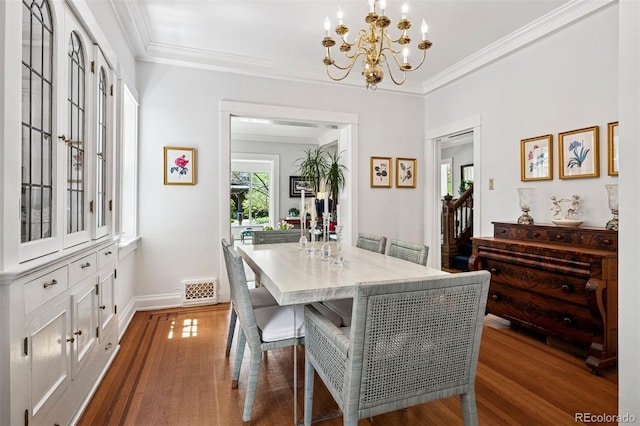 dining space with dark wood-style floors, a chandelier, ornamental molding, baseboards, and stairway