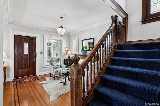entrance foyer featuring stairs, wood finished floors, ornamental molding, and baseboards