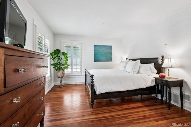 bedroom with wood finished floors, crown molding, and baseboards