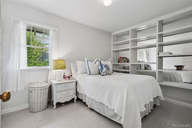 bedroom featuring hardwood / wood-style floors and baseboards