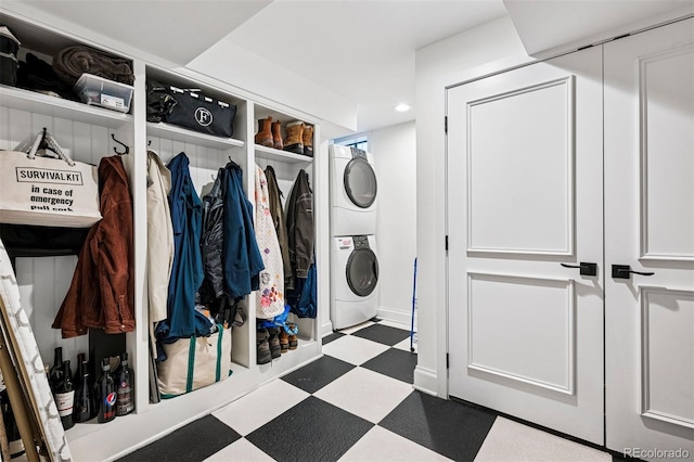 laundry room with stacked washer and clothes dryer, tile patterned floors, and recessed lighting