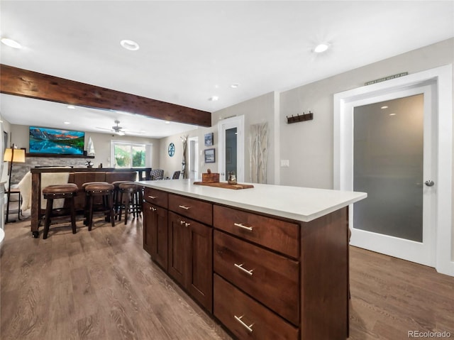 kitchen featuring a center island, hardwood / wood-style floors, and beam ceiling