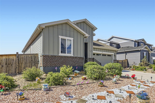 6924 E 118th Pl, Thornton, CO 80233 - view of front of home featuring board and batten siding, a garage, brick siding, and driveway