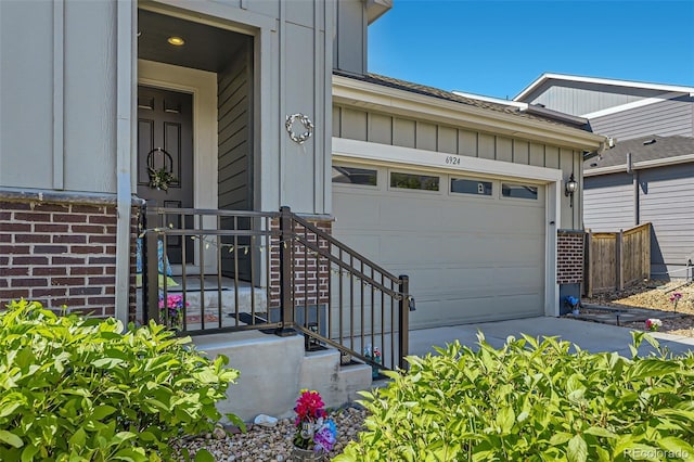 6924 E 118th Pl, Thornton, CO 80233 - view of exterior entry featuring board and batten siding, concrete driveway, brick siding, and a garage