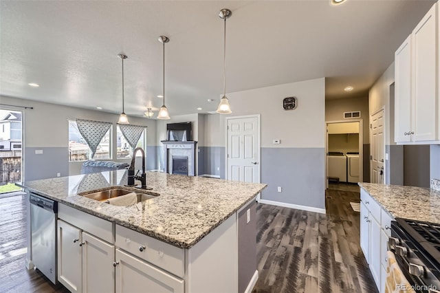 6924 E 118th Pl, Thornton, CO 80233 - kitchen featuring washing machine and dryer, a sink, stainless steel appliances, dark wood-type flooring, and white cabinetry