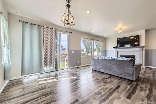 6924 E 118th Pl, Thornton, CO 80233 - living area with a tiled fireplace, baseboards, wood finished floors, a chandelier, and recessed lighting