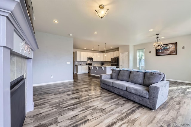 6924 E 118th Pl, Thornton, CO 80233 - living room with dark wood finished floors, recessed lighting, baseboards, and a tile fireplace