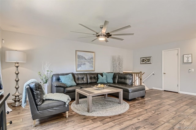 living area with light wood-style flooring, baseboards, and ceiling fan