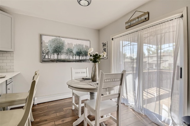 dining space with baseboard heating and wood finished floors