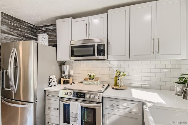 kitchen featuring light countertops, appliances with stainless steel finishes, and white cabinetry