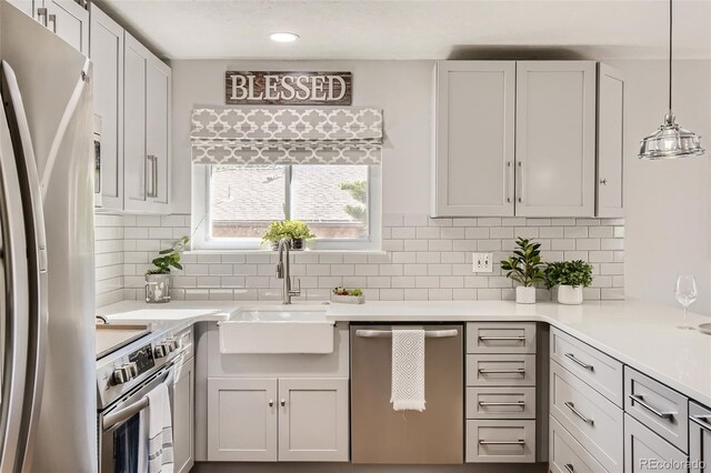 kitchen featuring a sink, stainless steel appliances, light countertops, and white cabinetry