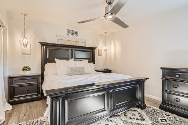 bedroom with baseboards, ceiling fan, and light wood finished floors