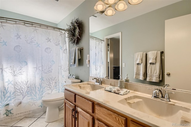 bathroom featuring double vanity, a sink, toilet, and tile patterned floors