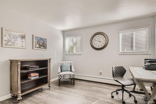 office space featuring baseboard heating, baseboards, and wood finished floors