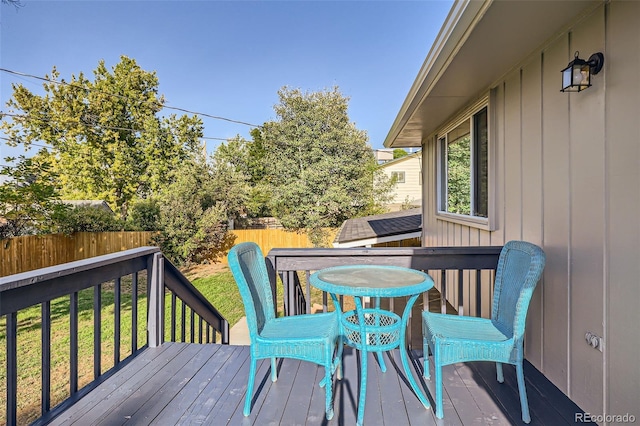 deck with a yard, outdoor dining space, and a fenced backyard