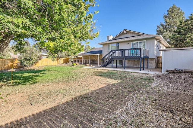 rear view of house featuring a patio, a fenced backyard, stairway, a wooden deck, and a chimney