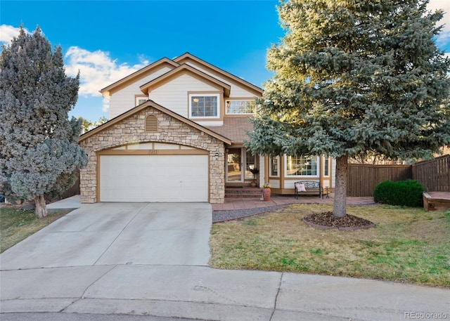 traditional-style house featuring a garage, fence, driveway, and a front lawn