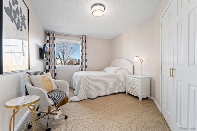 bedroom with light carpet, a textured ceiling, and baseboards