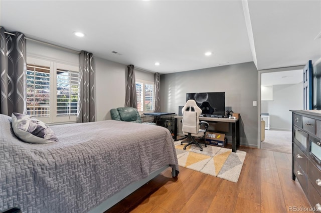 bedroom with baseboards, visible vents, wood finished floors, and recessed lighting