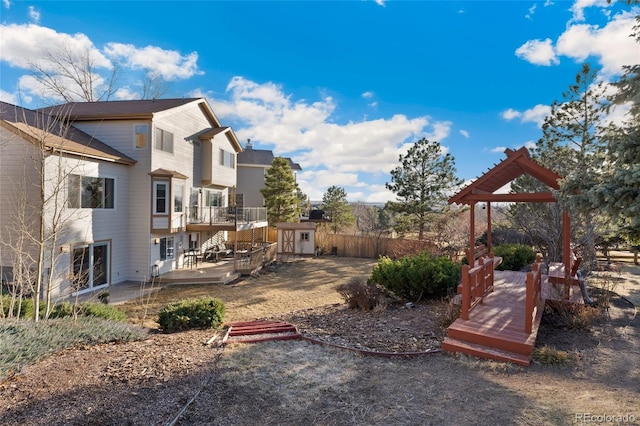 exterior space with a shed, fence, a deck, and an outdoor structure