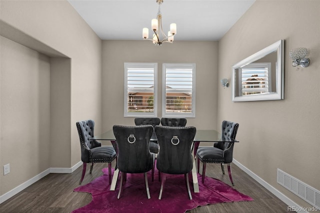 dining space with visible vents, baseboards, wood finished floors, and an inviting chandelier
