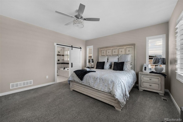 bedroom with ceiling fan, carpet flooring, ensuite bathroom, and a barn door