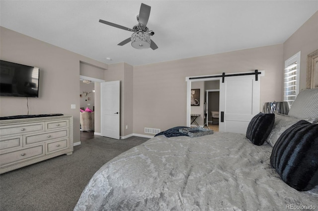 carpeted bedroom with baseboards, a ceiling fan, a barn door, and visible vents
