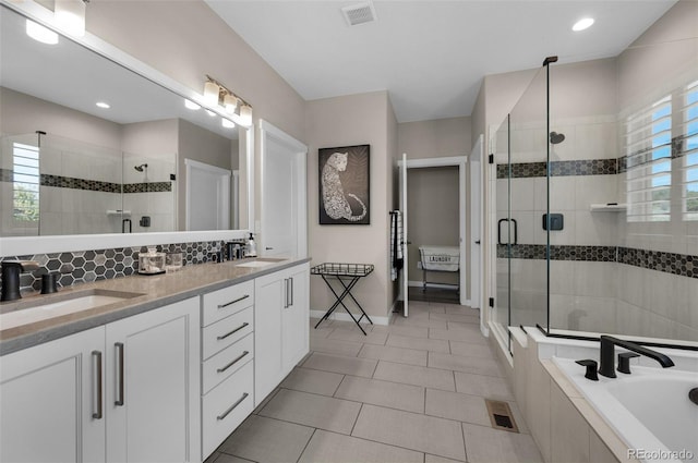 full bath with visible vents, a shower stall, a sink, and tile patterned flooring
