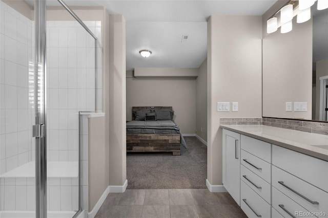 bathroom with vanity, baseboards, ensuite bathroom, and a stall shower